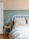 white bed in sage green room