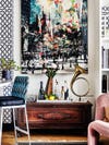 Artwork and chest between kitchen and bookshelf