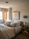 neutral bedroom with art over bed